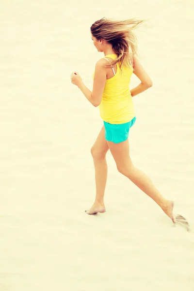 Молодая женщина бегает по пляжу — стоковое фото