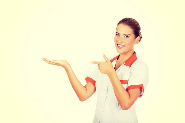 Médica ou enfermeira sorridente apontando para algo — Fotografia de Stock