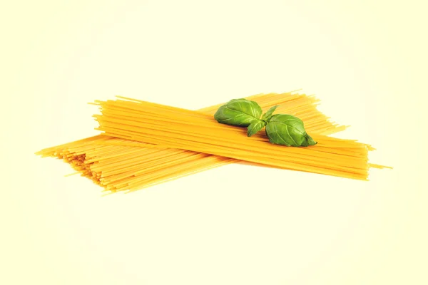 Uncooked dry fettuccine pasta  with green basil — Stock Photo, Image