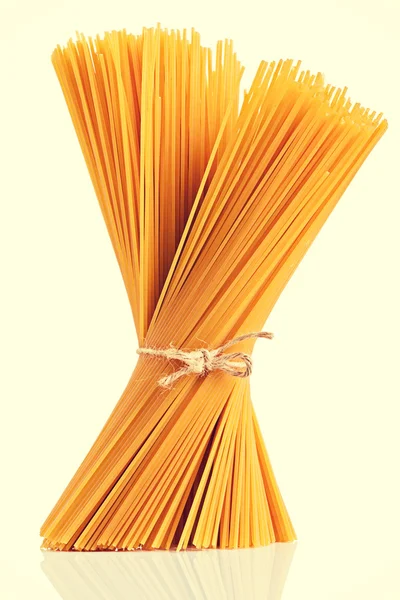 Uncooked dry fettuccine pasta isolated on a white background — Stock Photo, Image