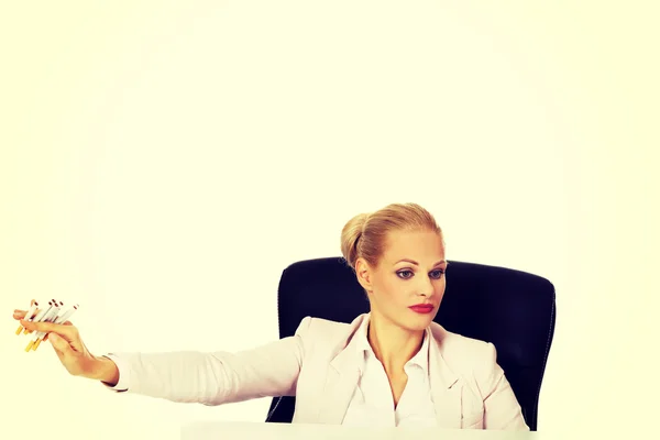 Mujer de negocios sentada detrás del escritorio no quiere fumar —  Fotos de Stock