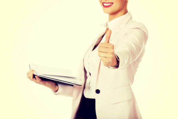 Sonríe mujer de negocios sosteniendo notas abiertas y mostrar el pulgar hacia arriba — Foto de Stock