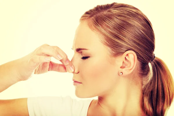 Junge Frau hält sich wegen schlechten Geruchs die Nase — Stockfoto