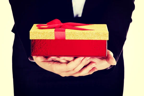 Woman holding christmas present with red bow — Stock Photo, Image