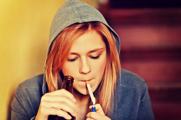 Tienervrouw die bier drinkt en sigaretten rookt — Stockfoto