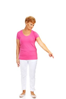 Yaşlı, mutlu bir kadın bir şeyi işaret ediyor.