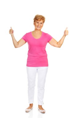 Başparmak yukarıya ile yaşlı bir smilig kadın