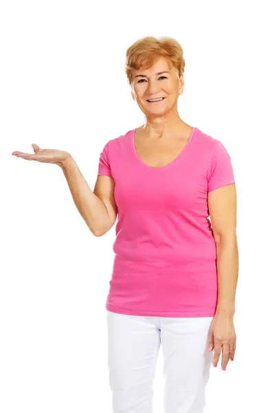 Una vieja mujer sonriente presentando algo —  Fotos de Stock