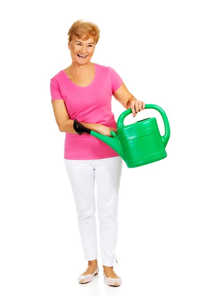 Smiling senior woman with green watering can — Stock Photo, Image