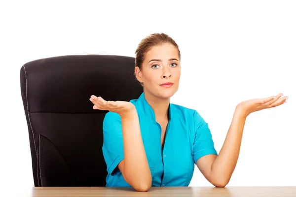 Medico donna seduto dietro la scrivania e parlare con qualcuno — Foto Stock
