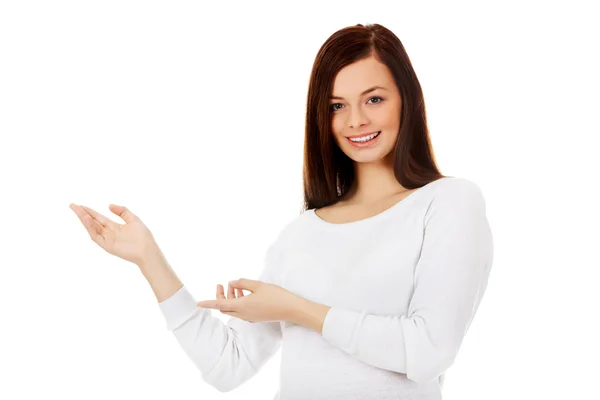 Smiling young woman shows something — Stock Photo, Image