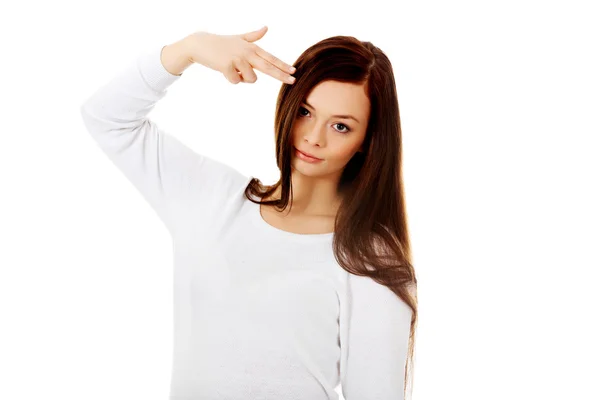 Young woman shoots herself in the head with finger gun gesture — Stock Photo, Image