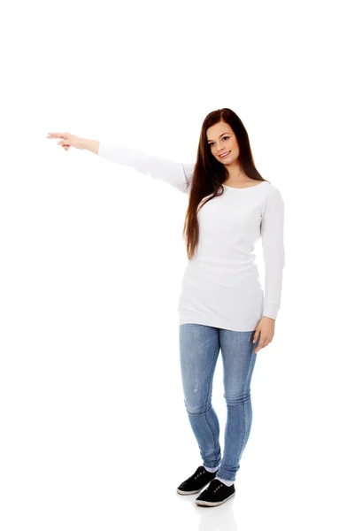 Smiling young woman shows something — Stock Photo, Image