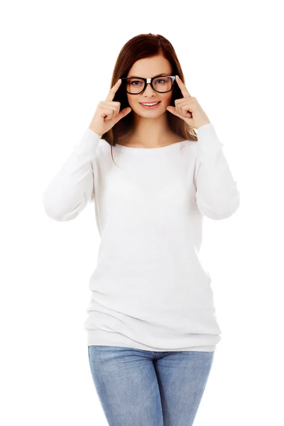 Młoda kobieta uśmiechający się poprawia okulary — Zdjęcie stockowe