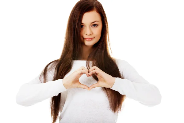 Beautiful young woman making a heart symbol with her hands — Stock Photo, Image