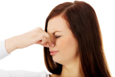 Young woman holding her nose because of a bad smell clipart
