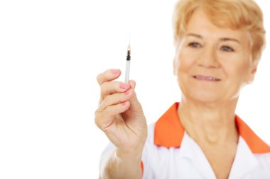 Yaşlı kadın doktor gülümseme ya da hemşire şırınga tutar