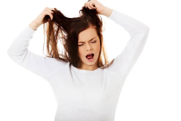 Ung arg kvinna drar hennes hår — Stockfoto