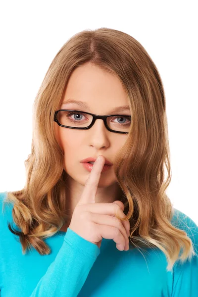 Teenage vrouw met vinger op lippen — Stockfoto