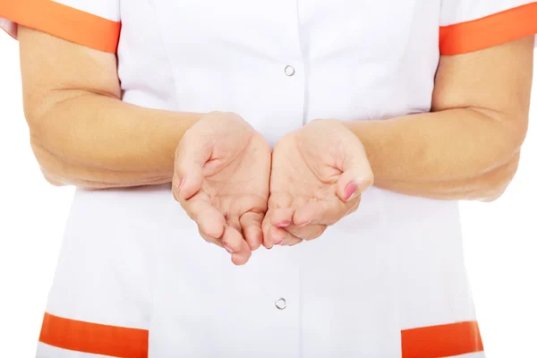 Starší ženský lékař nebo zdravotní sestra něco prezentovat na otevřené dlaně — Stock fotografie