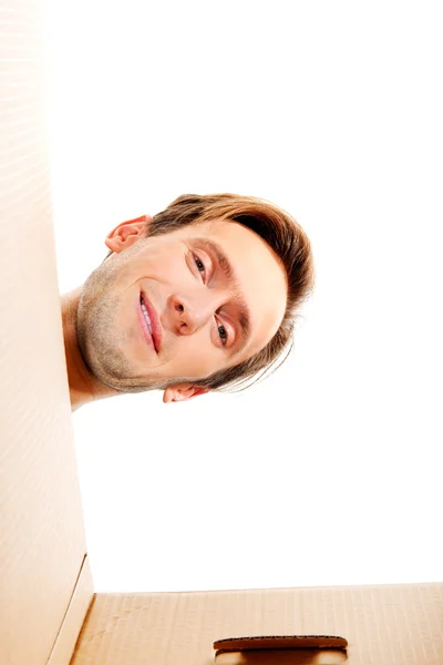 Happy young man looking inside box — Stock Photo, Image