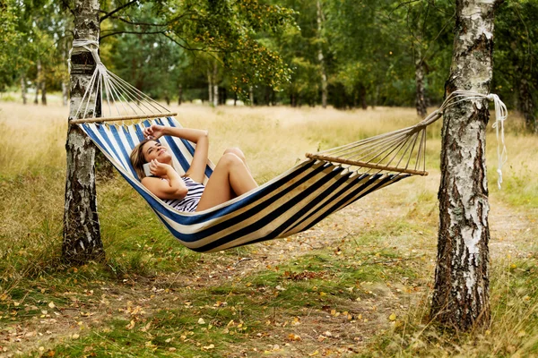 Young woman on hammock talking through a phone — Stock Photo, Image