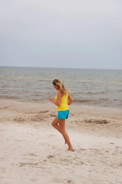 Jovem mulher correndo na praia — Fotografia de Stock