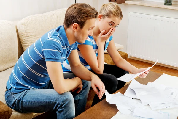 Besorgtes Ehepaar rechnet Rechnungen zu Hause ab — Stockfoto