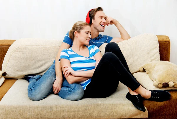 Pareja relajándose en el sofá, hombre escuchando música — Foto de Stock