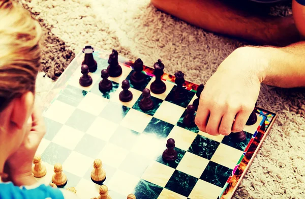 Focused happy couple playing chess on the floor — Stock Photo, Image