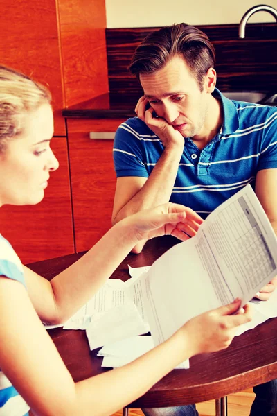 Bezorgd echtpaar dat rekeningen thuis berekent — Stockfoto