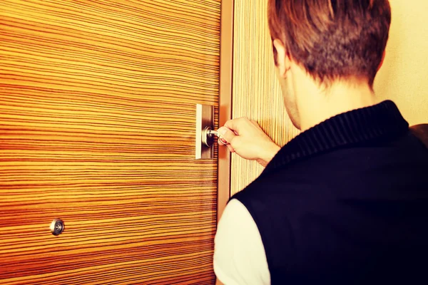 Genç adam eve dönüyor ya da evden çıkıyor.