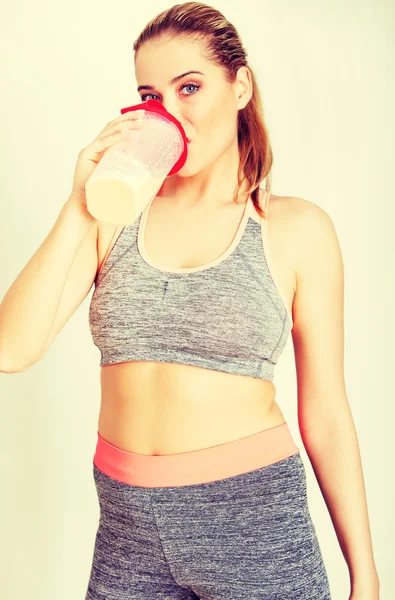 年轻的女运动员喝蛋白质奶昔 — 图库照片