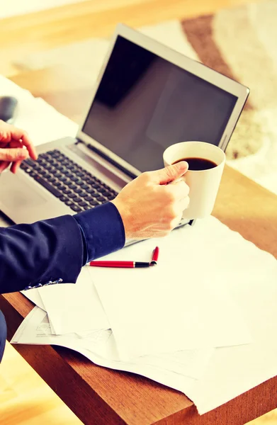 Man arbetar på laptop och dricka kaffe hemma — Stockfoto