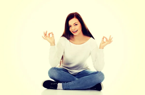 Young student woman sitting and doing yoga — Stock Photo, Image