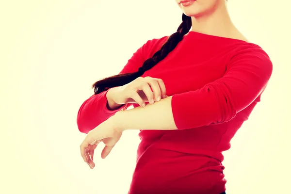 Jonge vrouw krabben van haar hand — Stockfoto