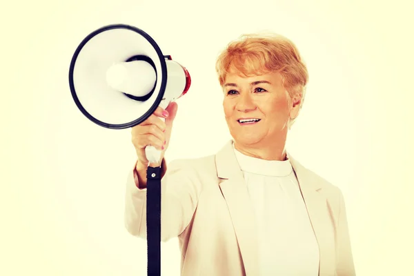 Senior sorrindo mulher gritando através de um megafone — Fotografia de Stock