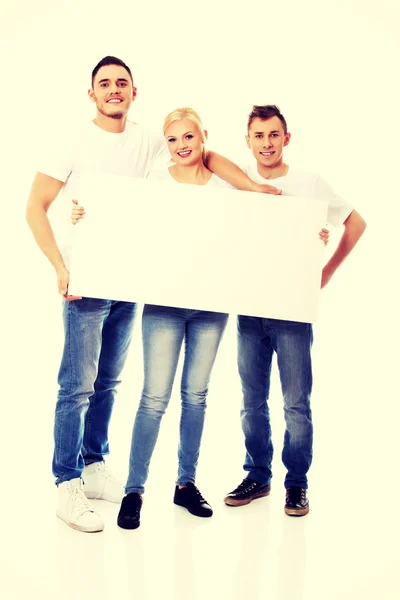 Group of happy friends holding empty banner — Stock Photo, Image