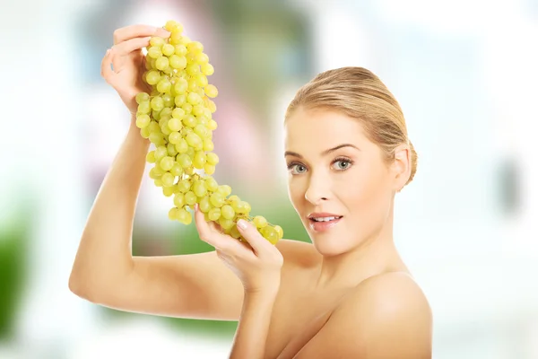 Widok z boku kobiety nagie gospodarstwa winogron — Zdjęcie stockowe