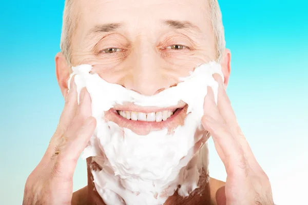 Zralý muž použitím pěny na holení — Stock fotografie