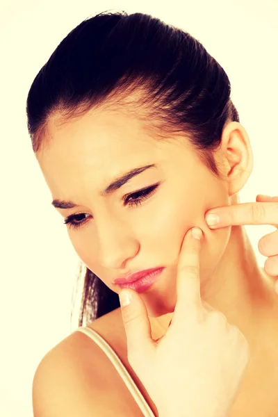 Teenage woman squeezing pimple. — Stock Photo, Image