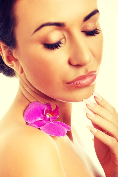 Woman with purple orchid petal on shoulder — Stock Photo, Image