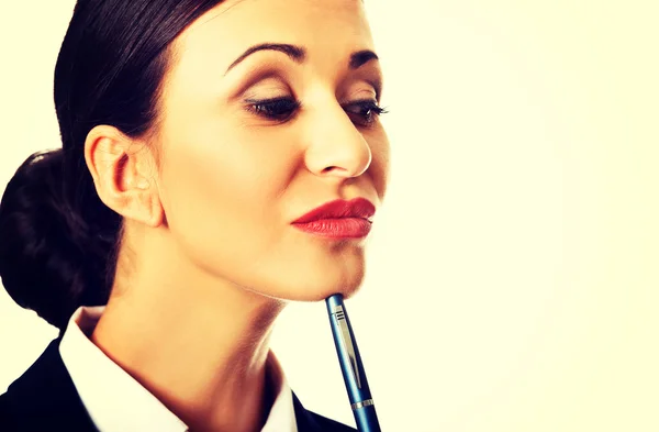 Thoughtful businesswoman holding a pen — Stock Photo, Image
