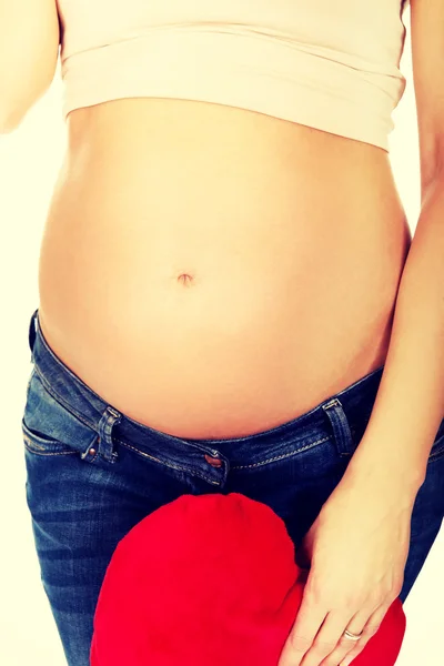 Pregnant woman with a heart pillow — Stock Photo, Image