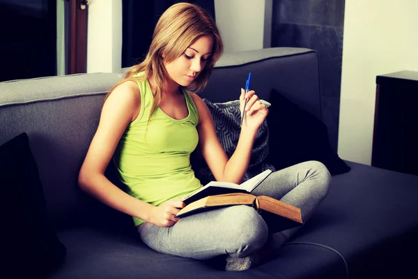 Junge Frau lernt Prüfung auf dem Sofa. — Stockfoto