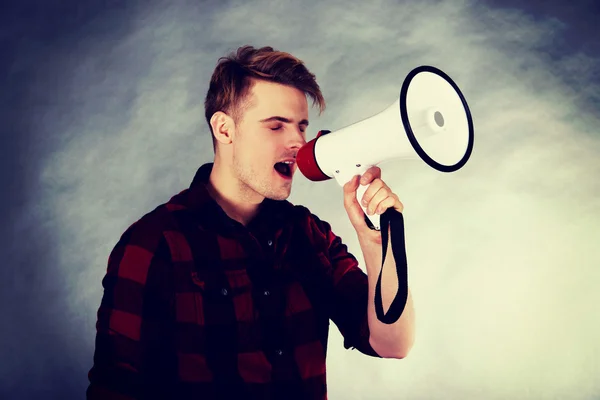 Young man shouting in megaphone. — Stock Photo, Image