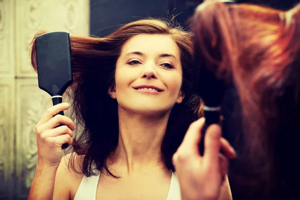 Brunette vrouw haar haren borstelen. — Stockfoto