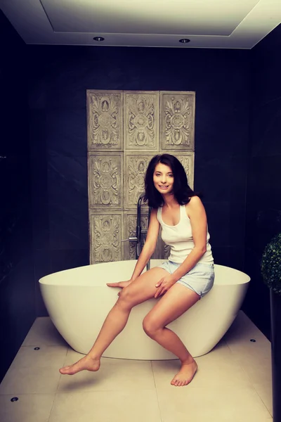 Beautiful woman sitting on bathtub. — Stock Photo, Image