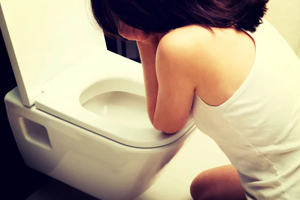 Frau erbricht sich in Toilette. — Stockfoto