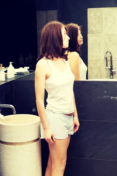 Mulher bonita natural olhando no espelho . — Fotografia de Stock